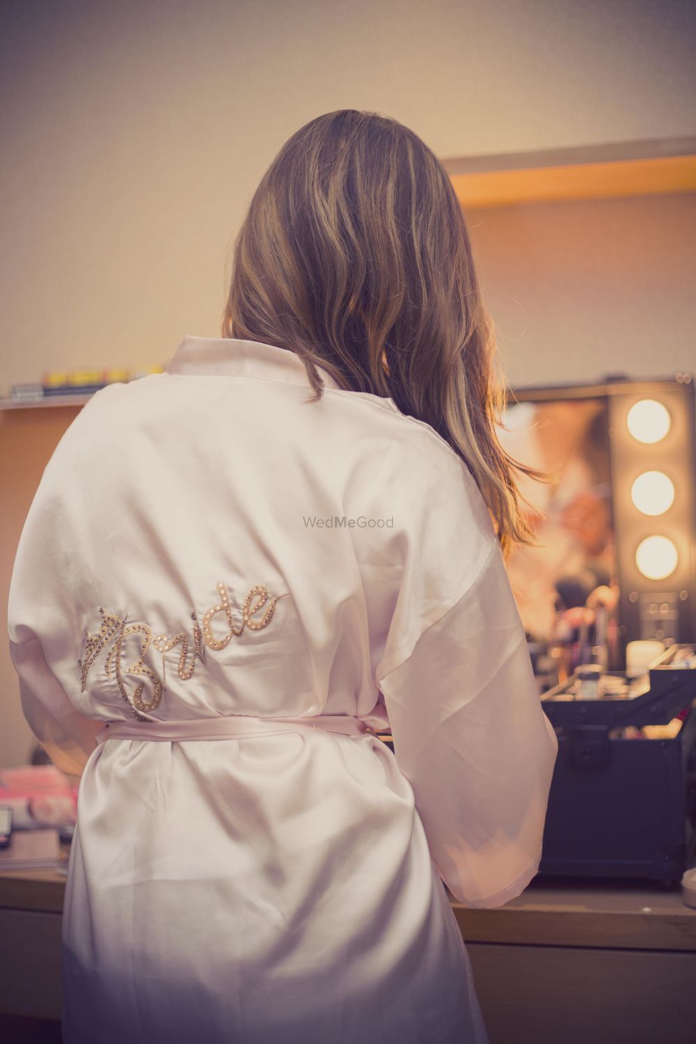 Photo of Bride getting ready shot wearing white robe