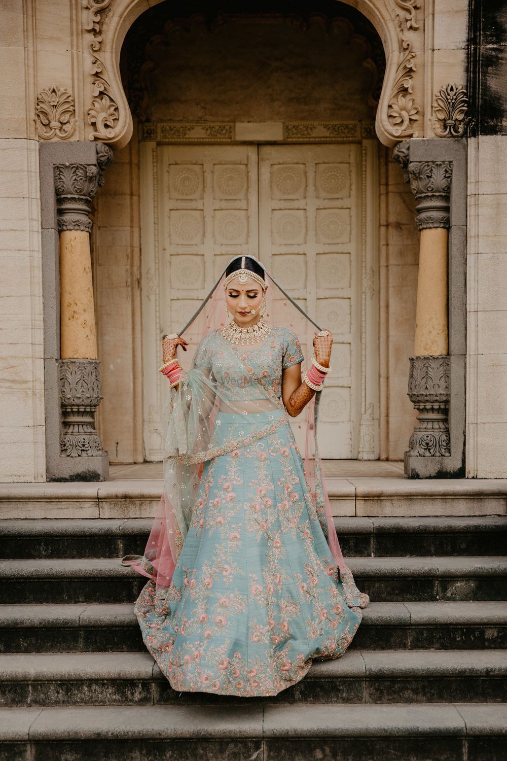 Photo of A bride in blue with a contrasting pink dupatta