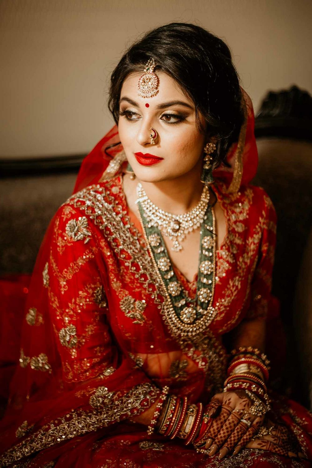 Photo of A bride in red with contrasting green jewellery