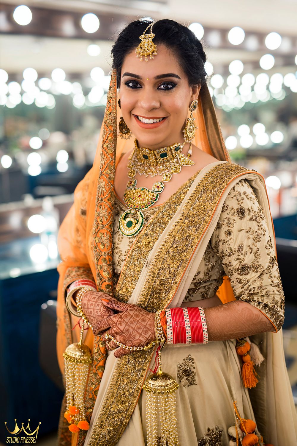 Photo of Orange and gold bridal look with orange kaleere and green jewellery