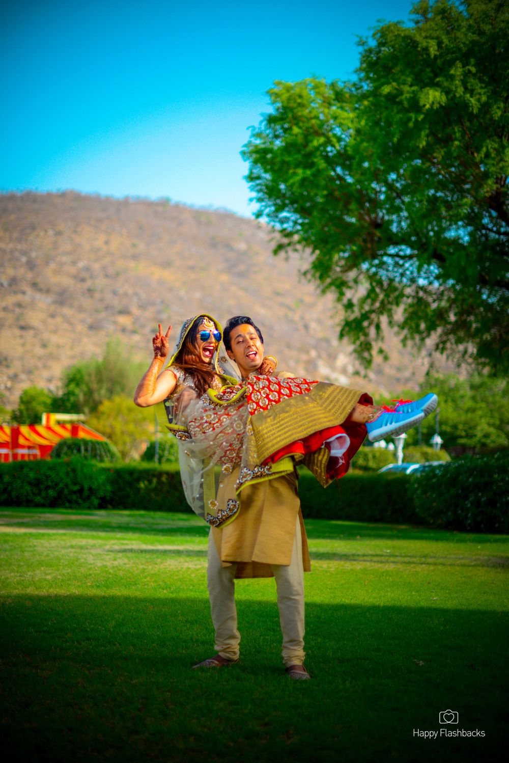 Photo of Fun couple shot with groom picking up bride