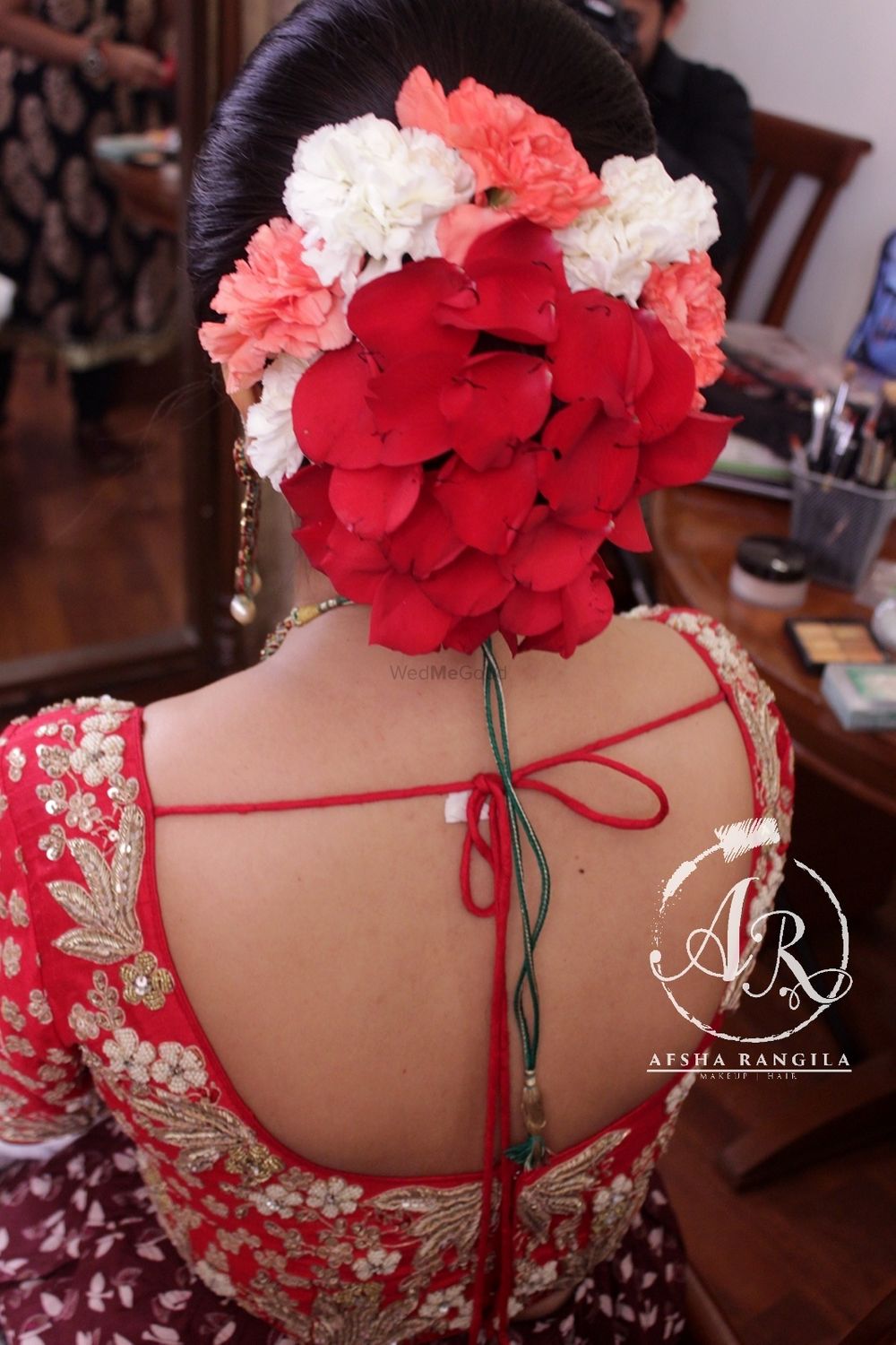 Photo of Red bridal bun with petals and flowers