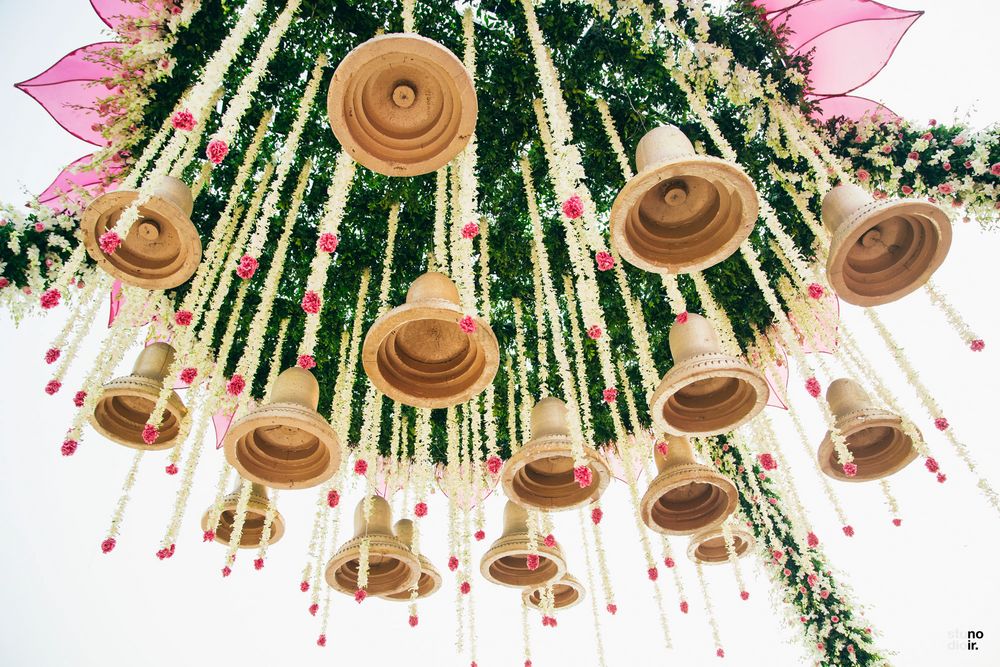 Photo of Unique mandap decor with hanging temple bells and floral strings