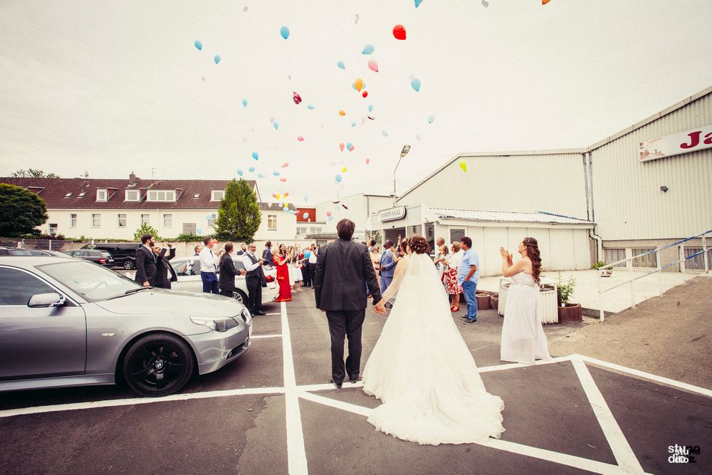 Photo of Guests releasing balloons on bride and groom entry