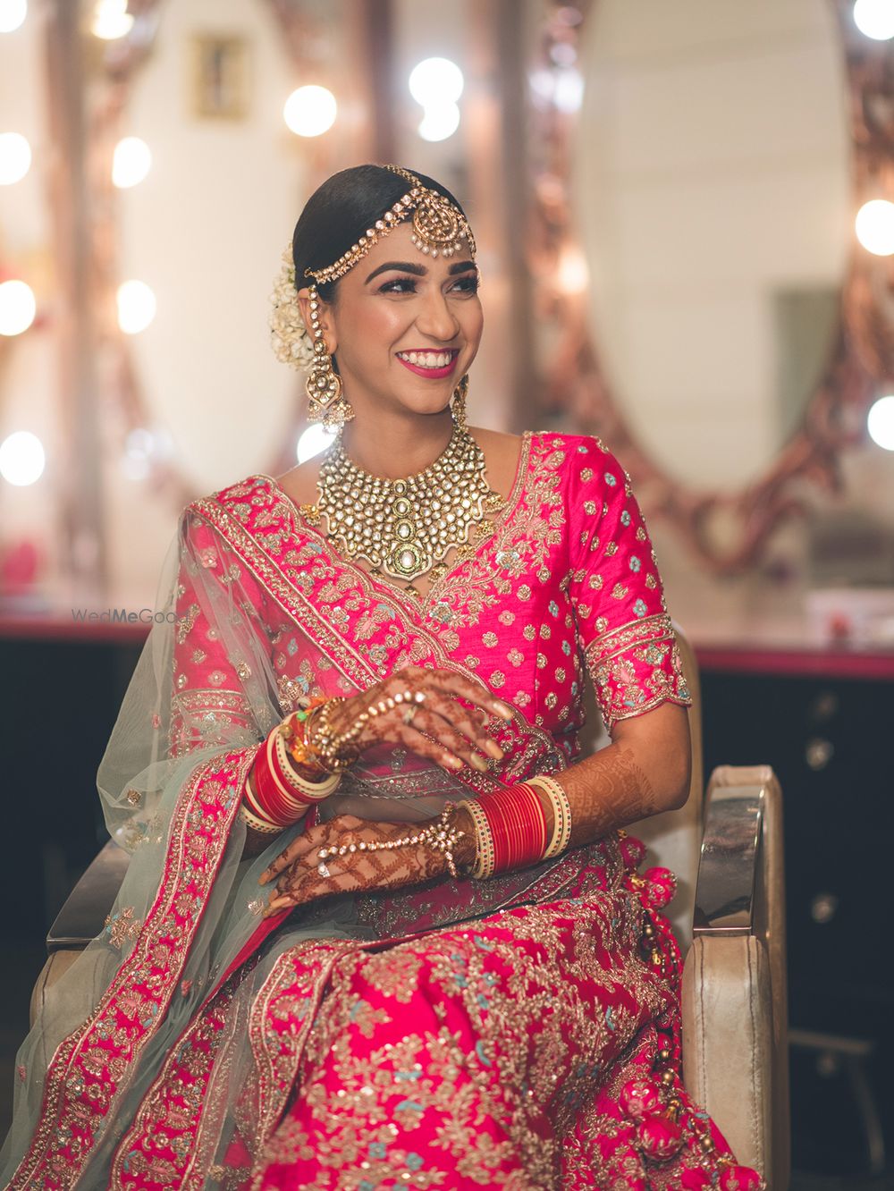 Photo of Happy bride dressed in a bright pink lehenga