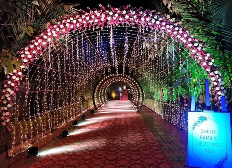 Photo of A stunning entrance decor with flowers and fairy lights.