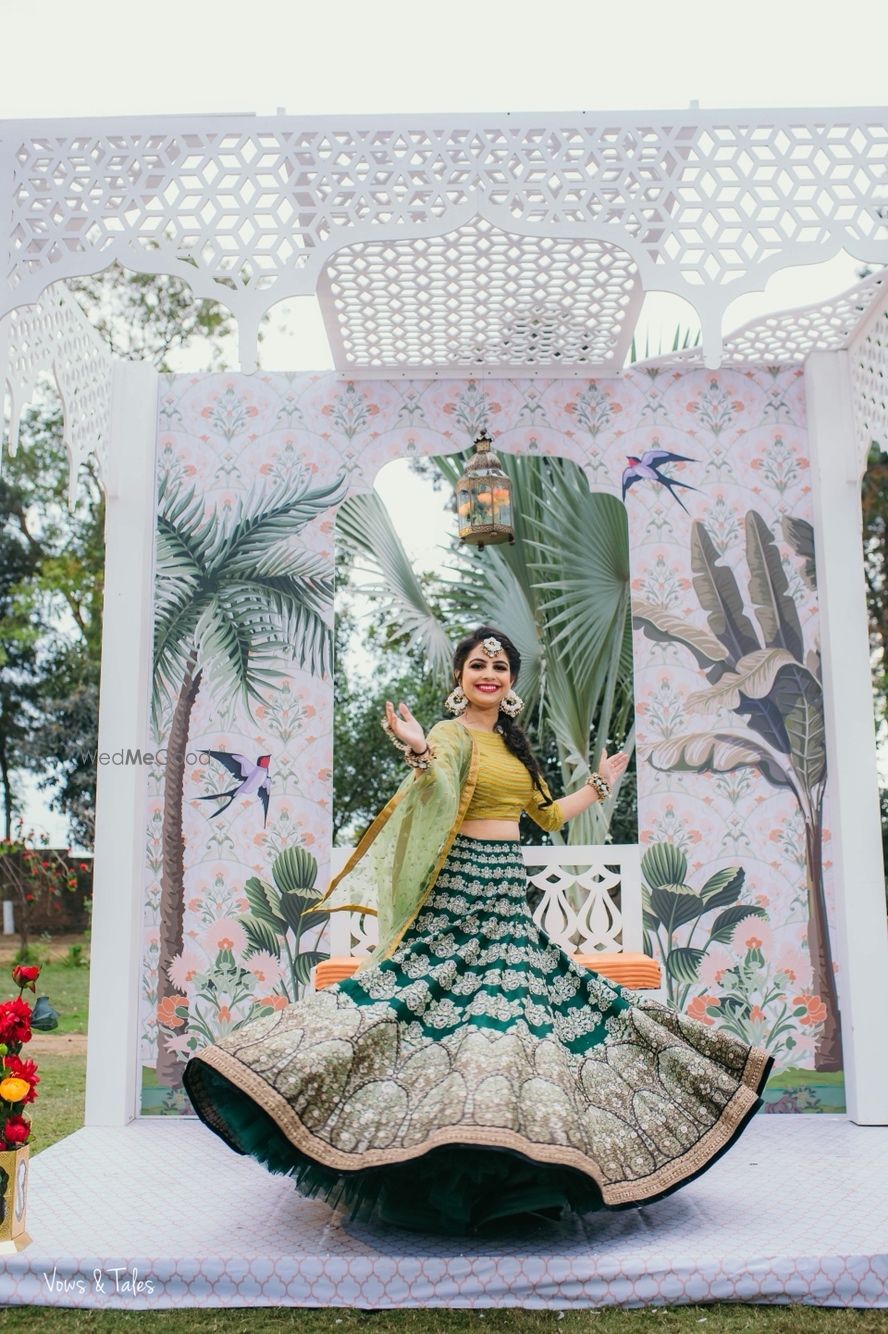 Photo of Bride twirling in dark and light green mehendi lehenga