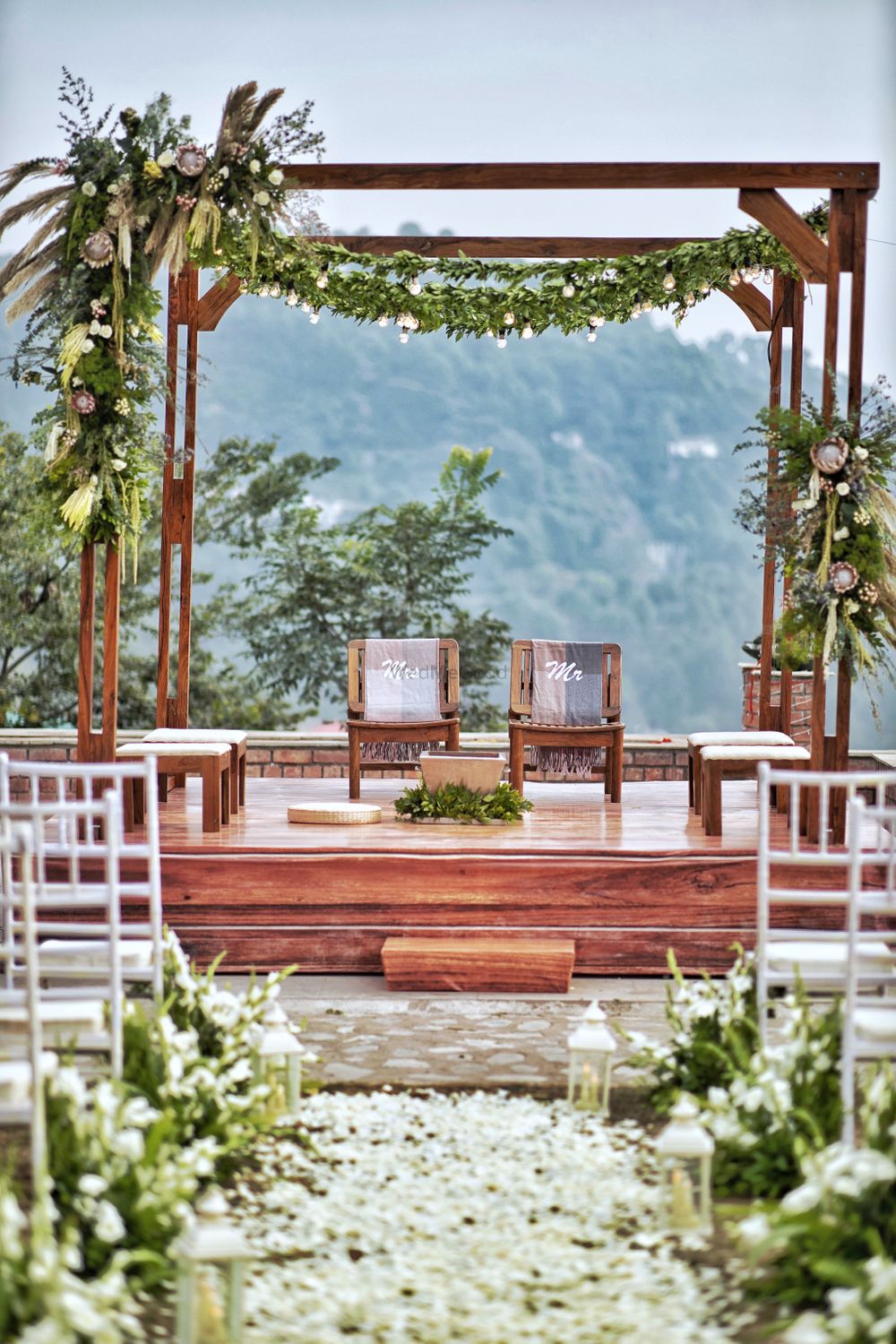 Photo of Rustic mandap with a scenic view of the hills in the backdrop.