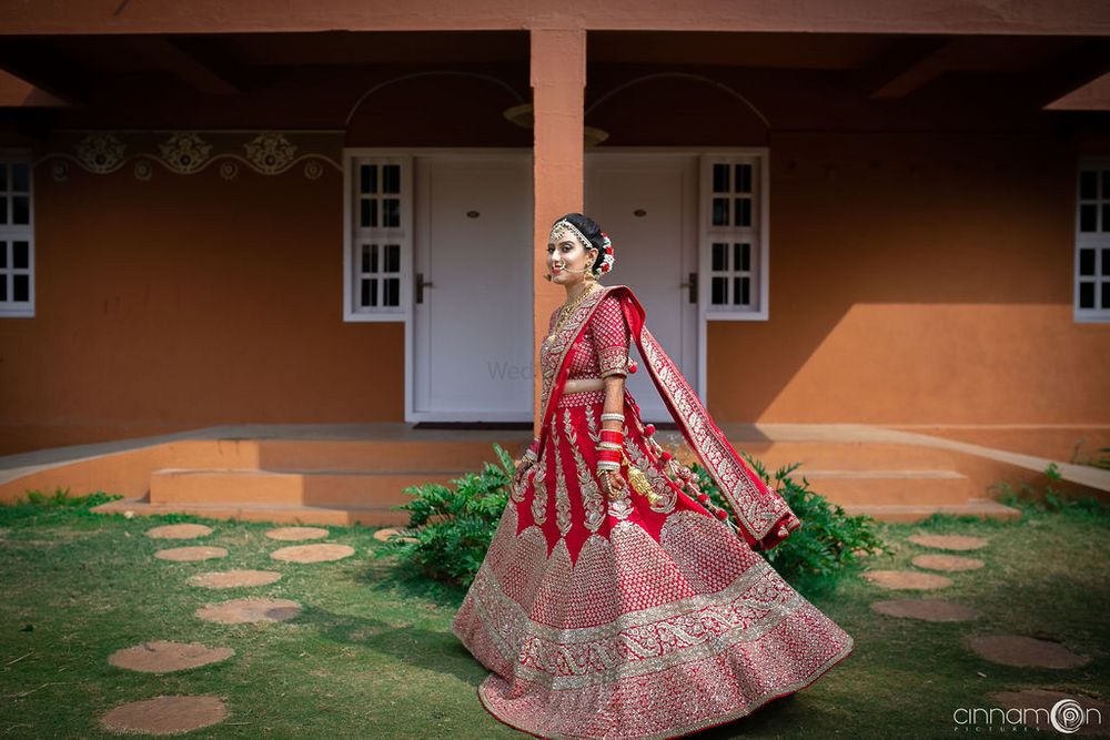 Photo of A bride twirling in a red lehenga