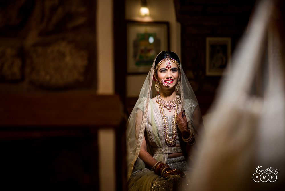 Photo of Bride looking at herself in mirror getting ready