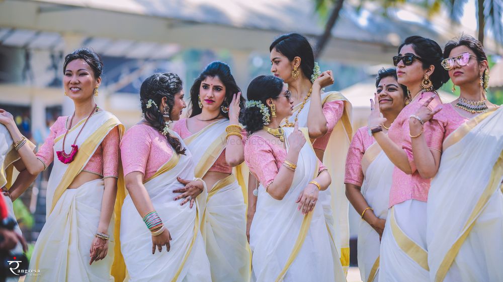 Photo of Coordinated bridesmaids in white and gold sarees with pink blouses