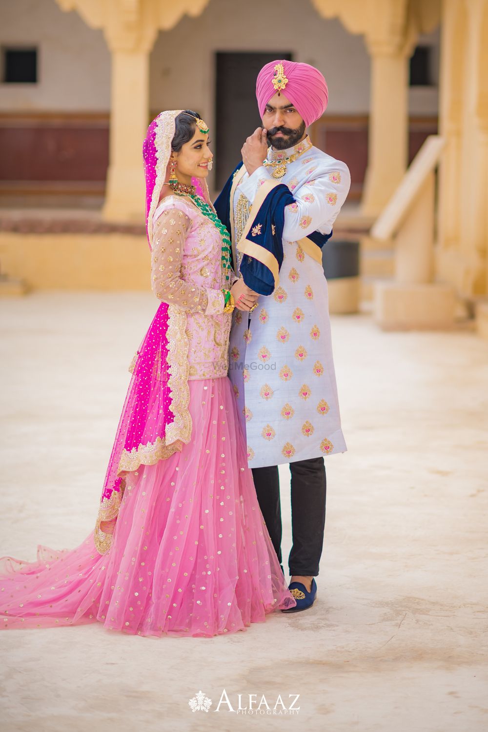 Photo of Coordinated bride and groom wearing light pink outfits
