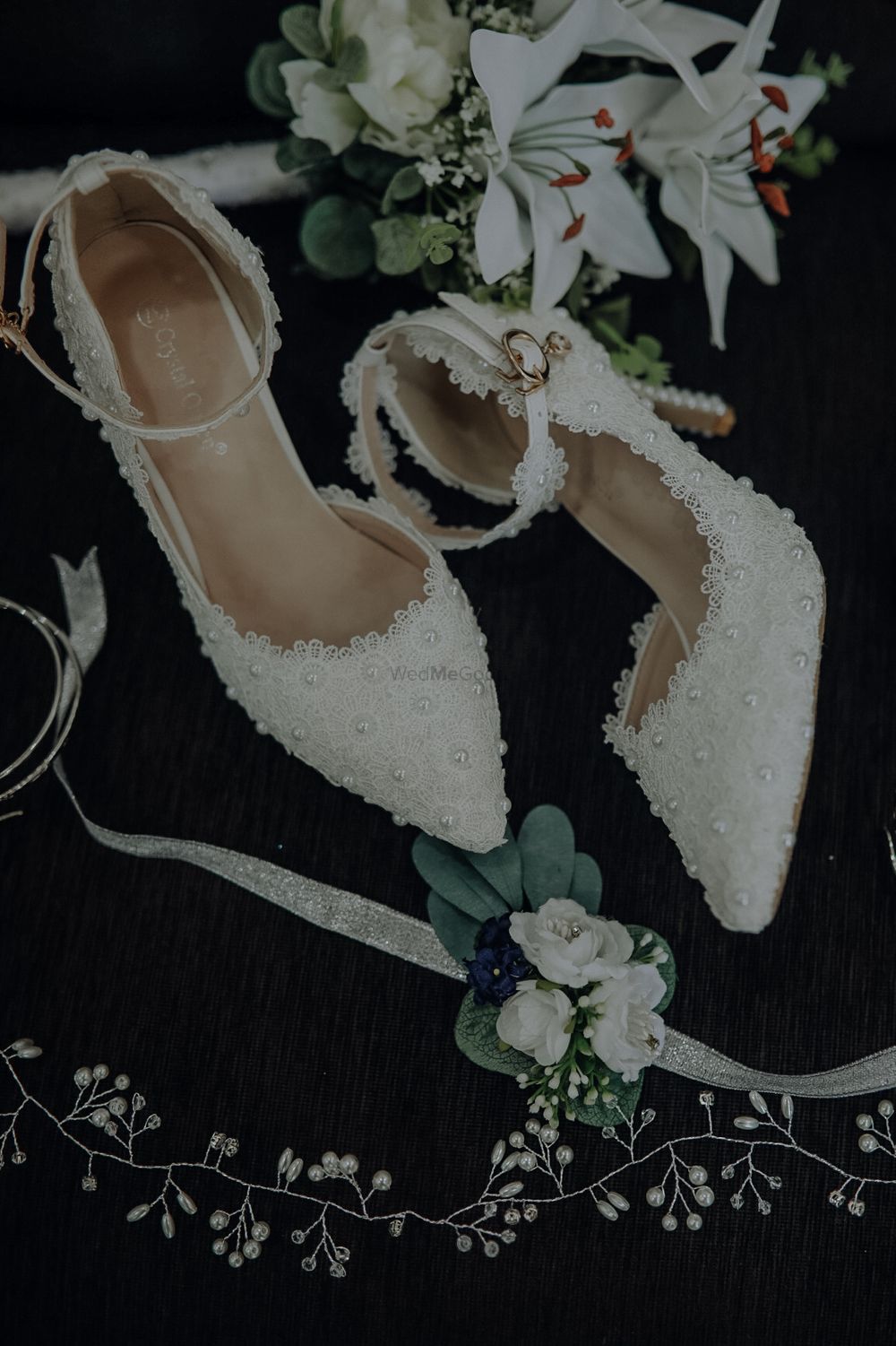 Photo of Bridal Footwear with lacey pattern and pearl embellishments.