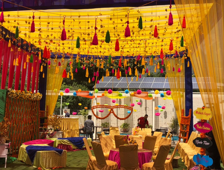 Photo of Colorful mehendi decor with hanging tassels and sunglasses