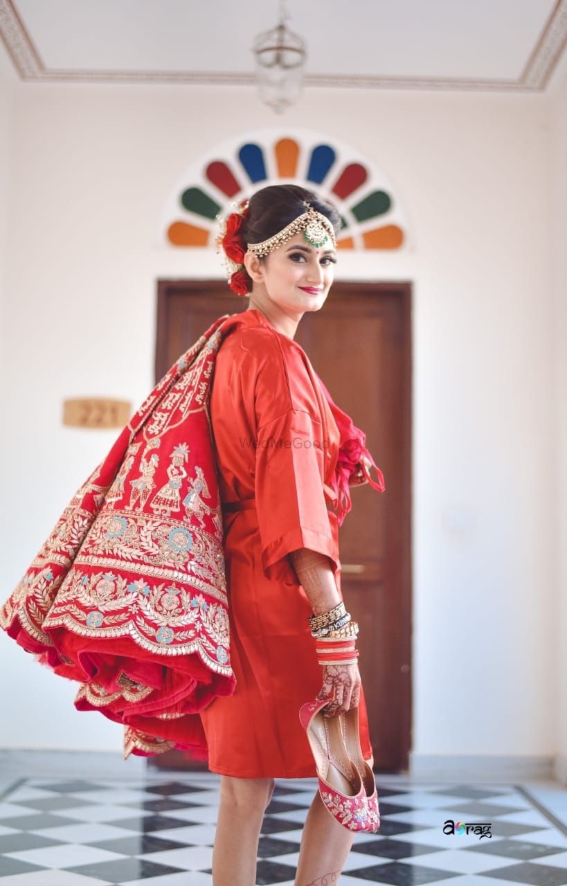 Photo of Bride getting ready shot holding her lehenga and shoes