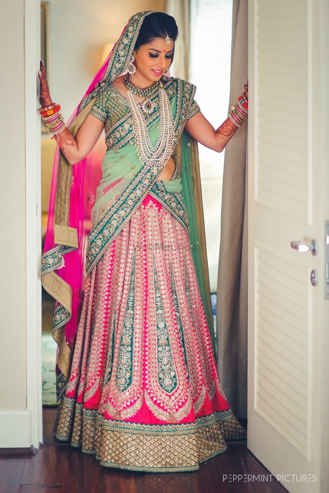 Photo of Bride in mint and bright pink bridal lehnega
