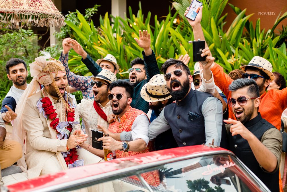 Photo of groom entering wedding with groomsmen and baraat in car