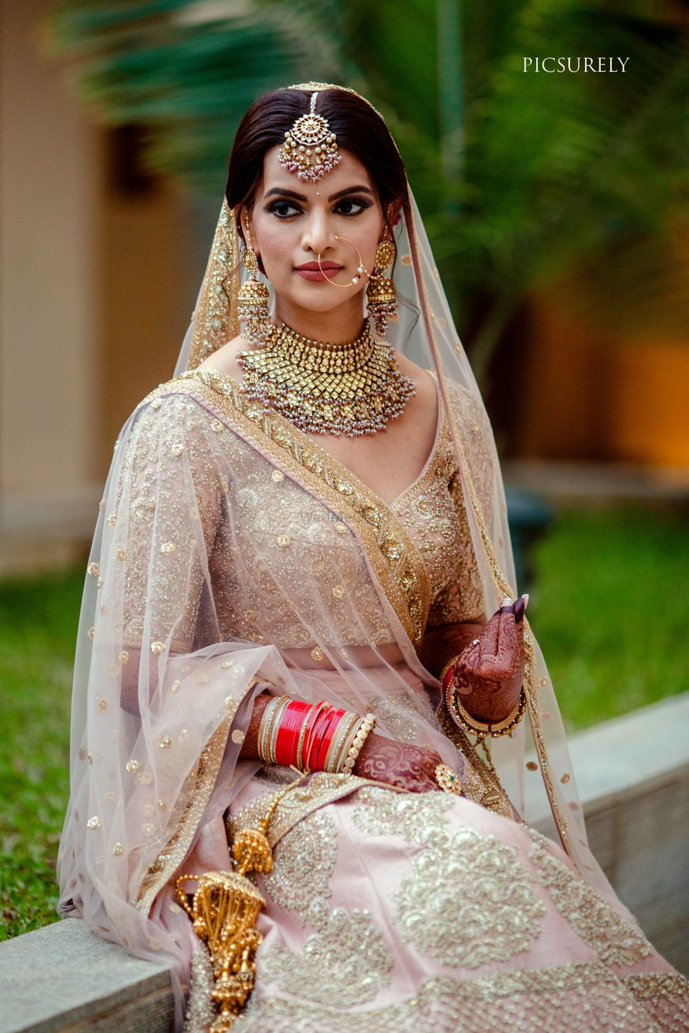 Photo of bride in soft pastel lehenga with matching jewellery