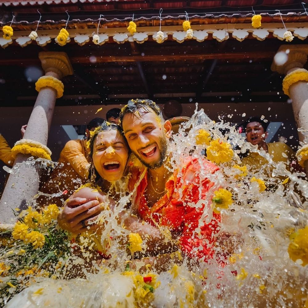 Photo of Fun haldi shot of the bride and groom as they are drenched in water