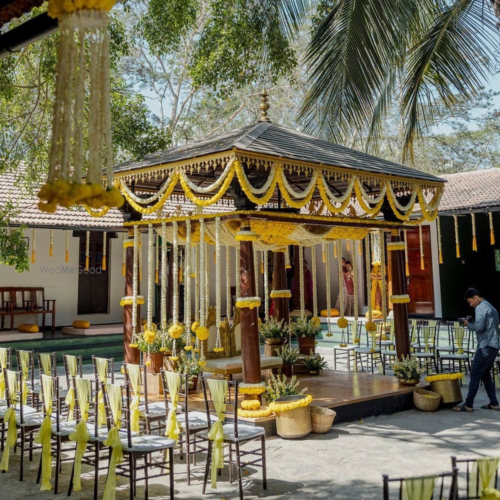 Photo of Simple and minimal mandap decor with wooden structure and gendaphool flowers