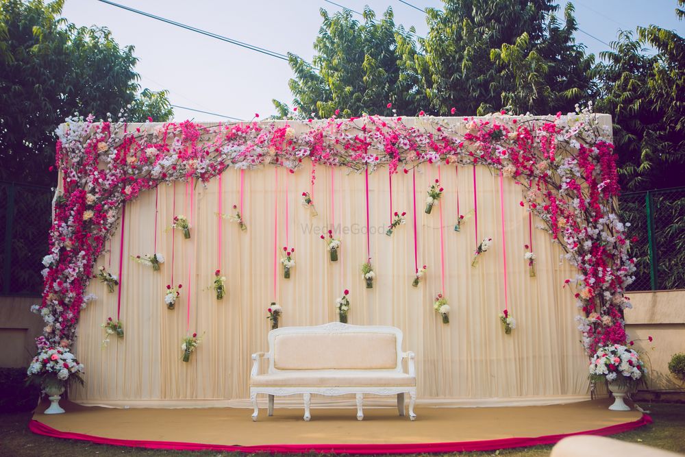 Photo of Unique engagement stage decor idea with florals in hanging bottles