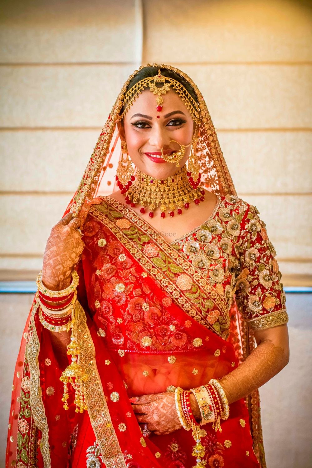 Photo of Bride in red lehenga and gold jewellery
