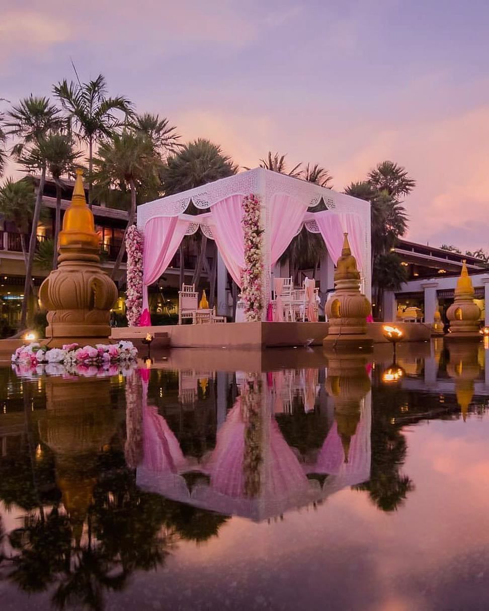 Photo of Light pink mandap with drapes by seaside