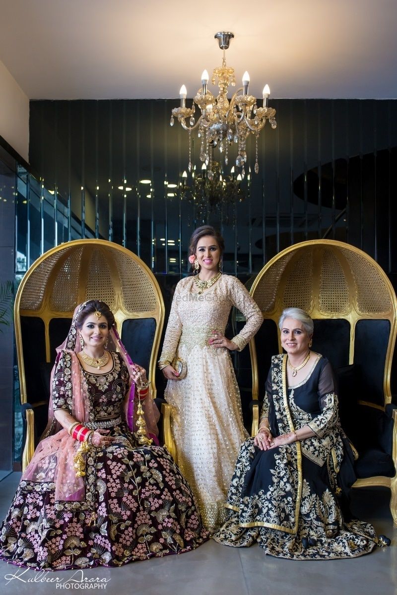 Photo of Bride with mother and sister on wedding day