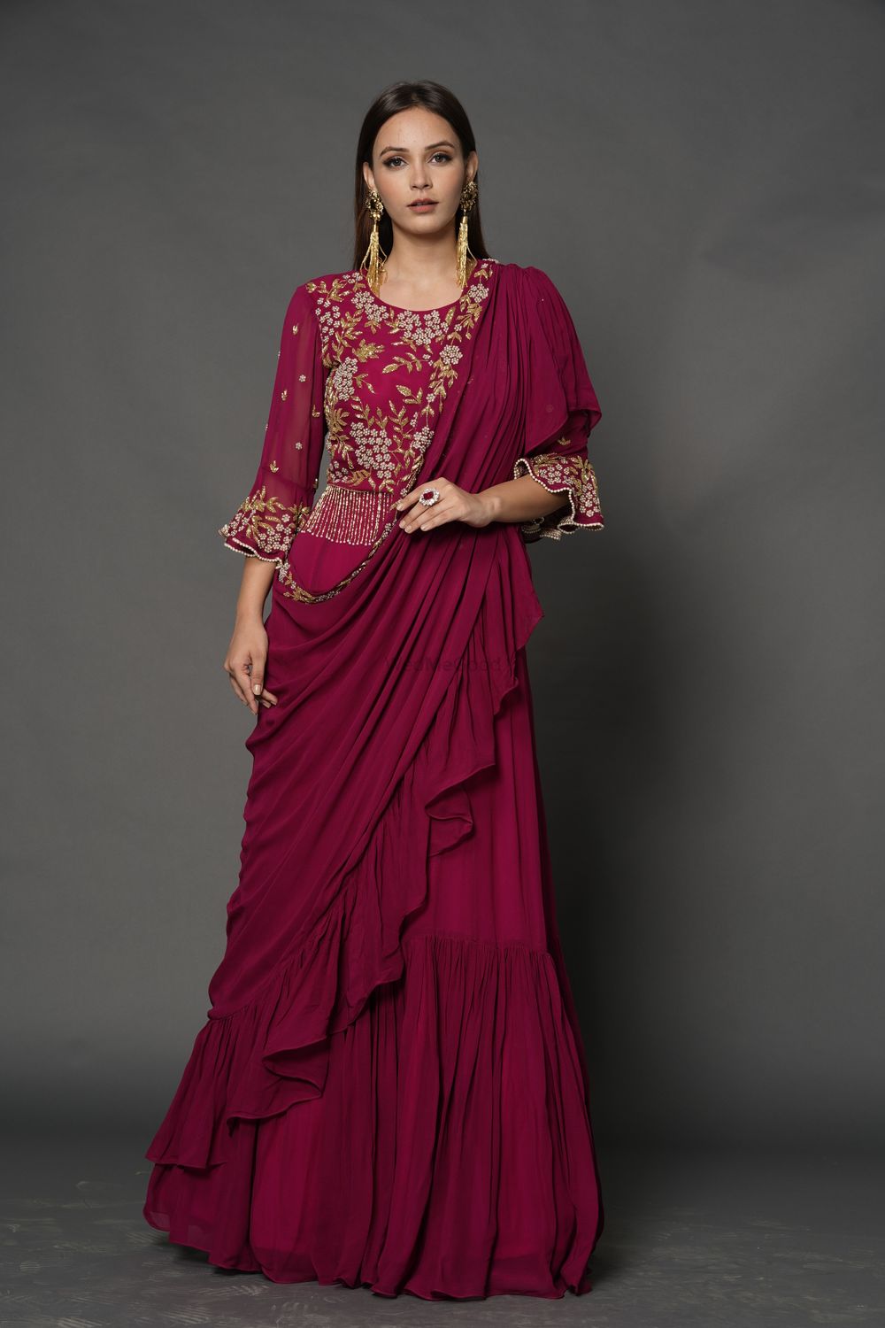 Photo of A dark pink saree gown with an embellished bodice.