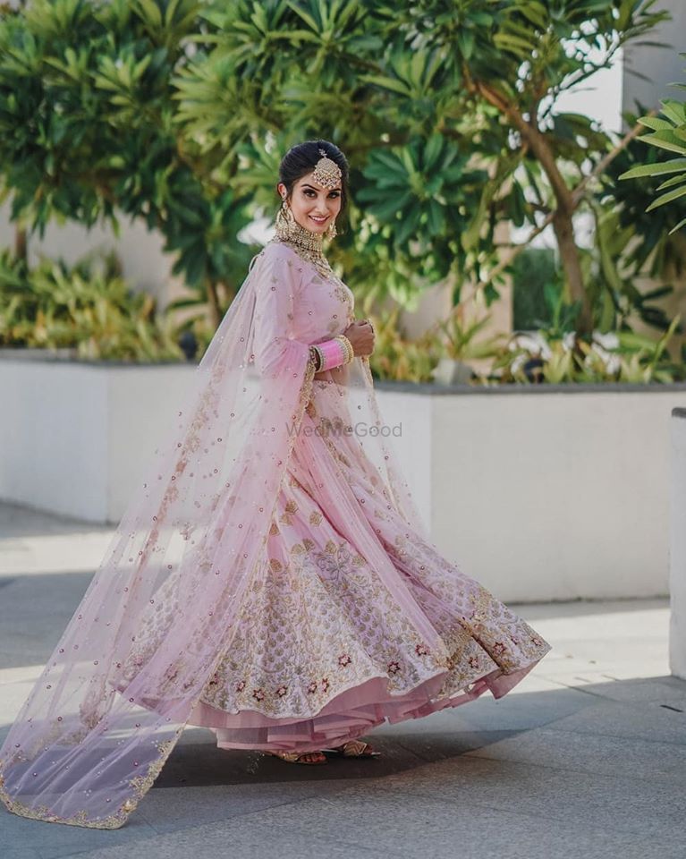Photo of Twirling shot of a bride dressed in light pink lehenga