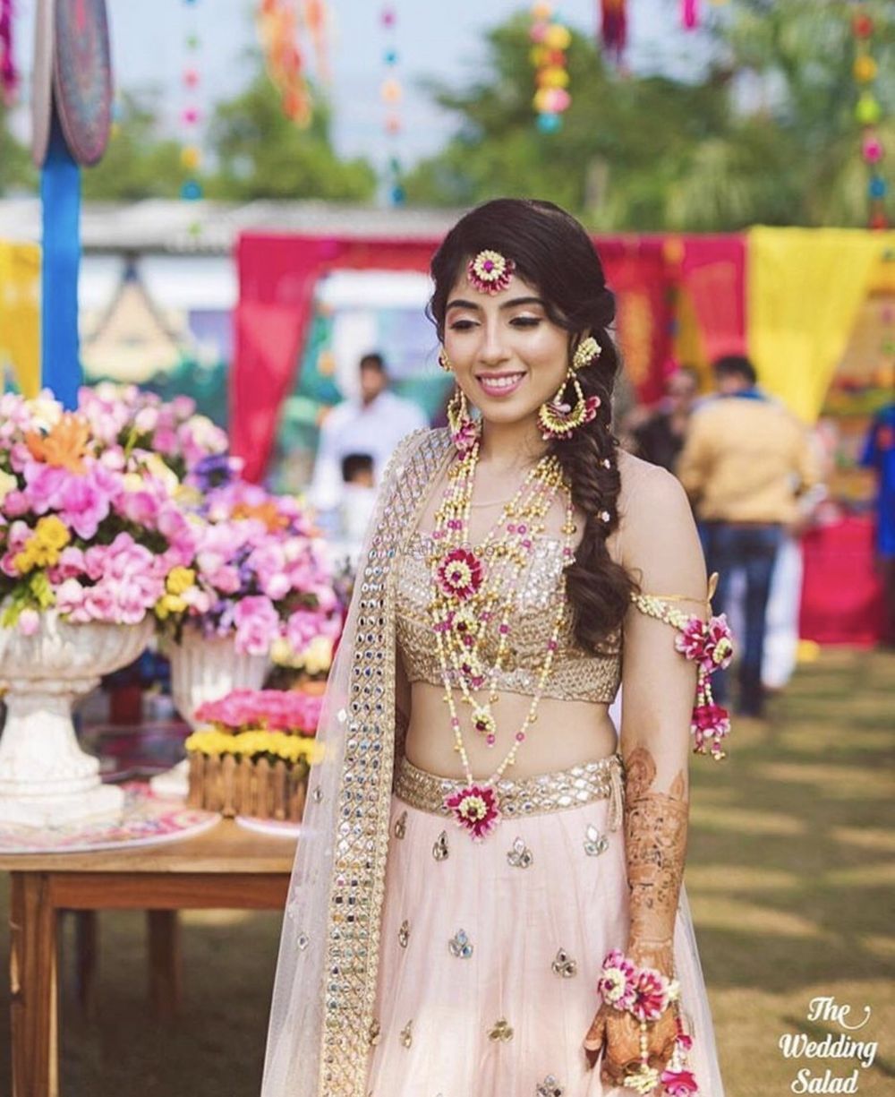 Photo of Pastel bride on mehendi with floral jewellery