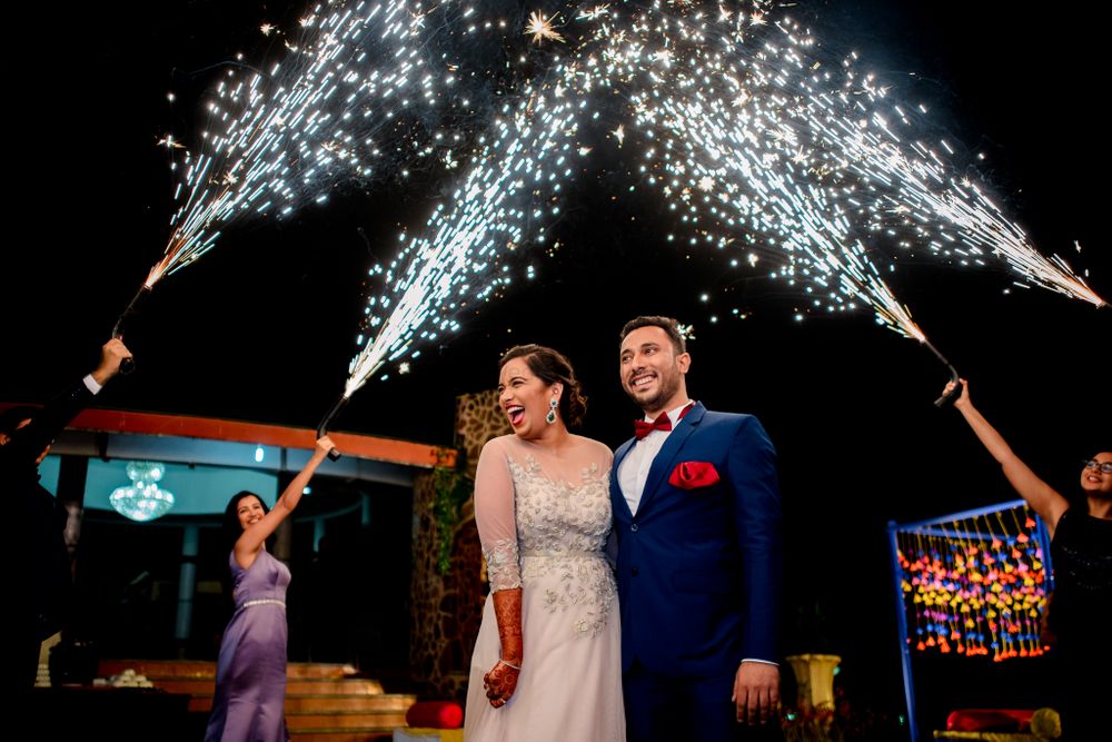 Photo of Couple entry on reception with guests holding cold pyros