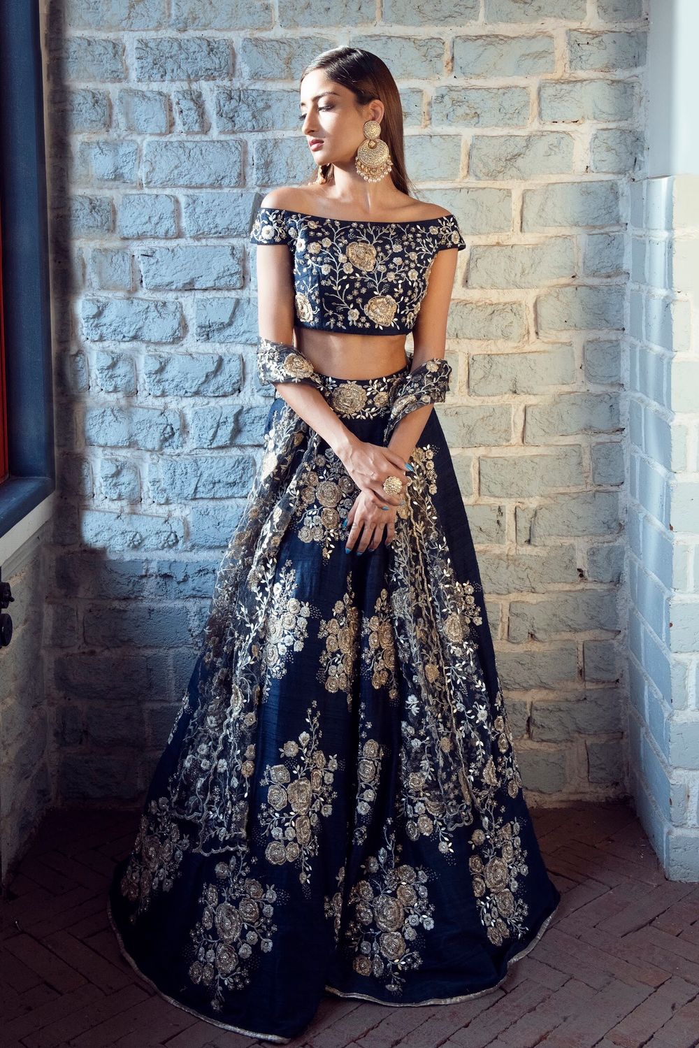 Photo of An off-shoulder engagement lehenga coupled with heavy earrings.