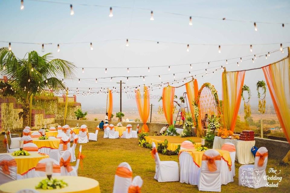 Photo of Orange and yellow theme outdoor round table setting