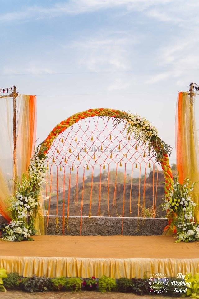 Photo of Orange and gold stage decor with jali backdrop