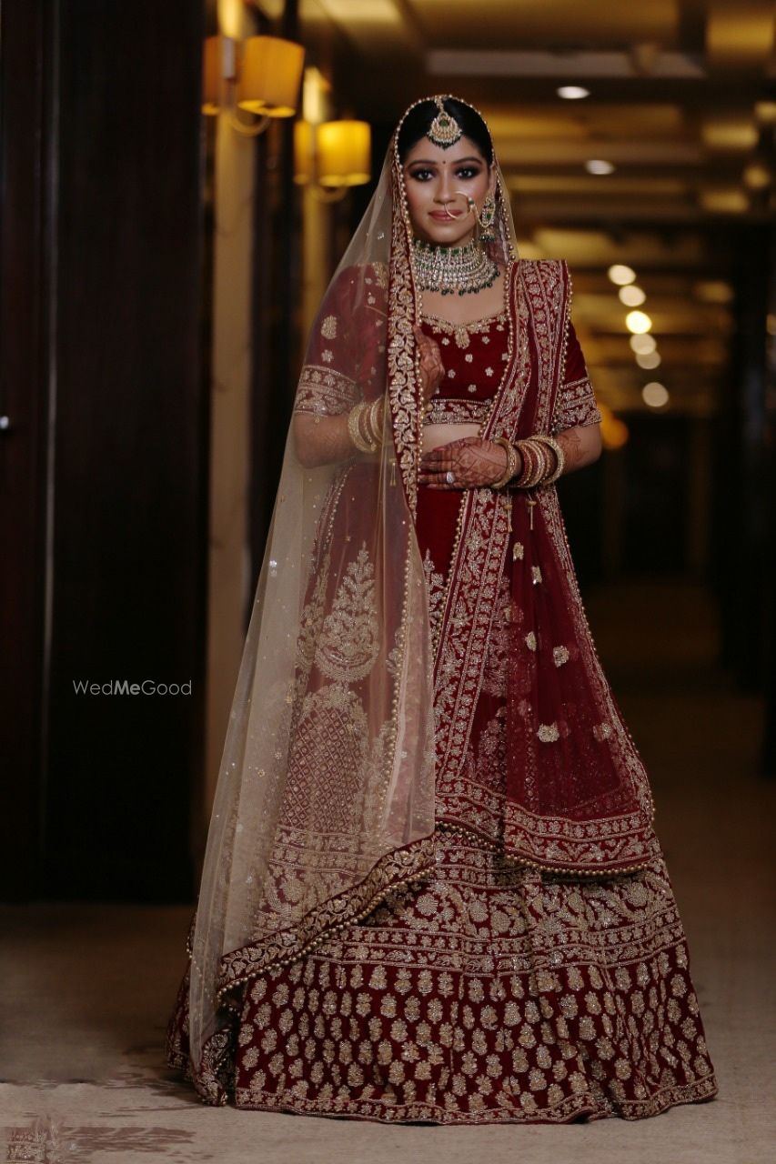 Photo of A beautiful bride in a stunning dark red lehenga and subtle makeup.