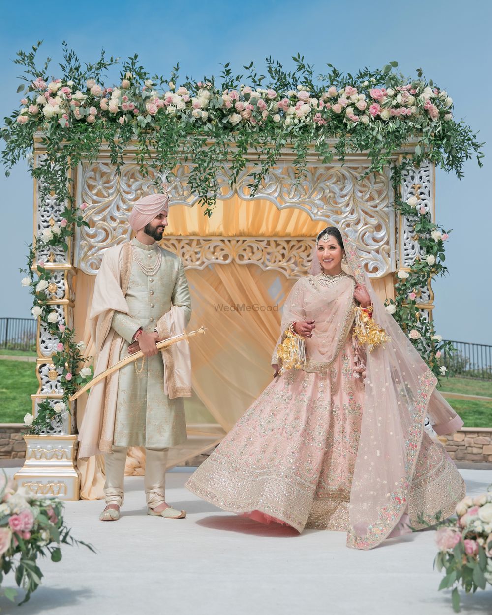 Photo of A punjabi couple in coordinated light pink outfits for their wedding