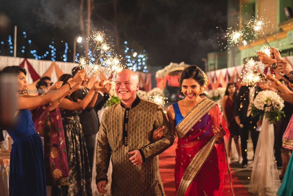 Photo of Bride and groom entry or exit with guests holding sparklers