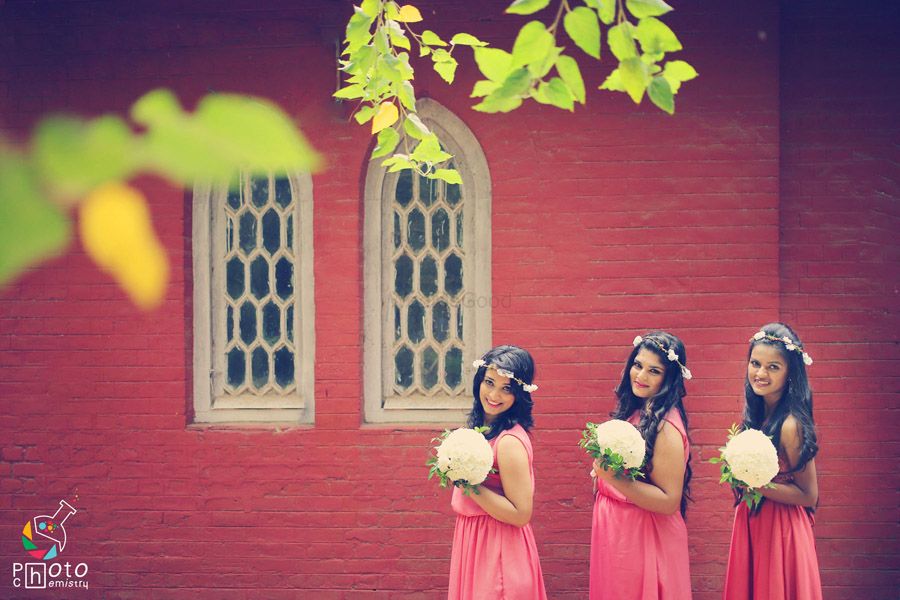 Photo of Coordinated bridesmaids in pink gowns and floral hair wreaths