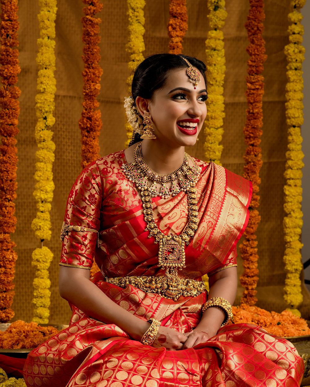 Photo of A south Indian bride in a jewel-tone kanjeevaram and stunning temple jewellery