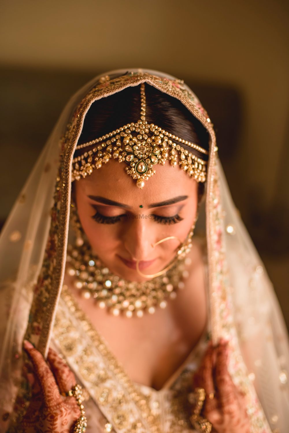 Photo of A bride in a gold lehenga with complimenting jewlery