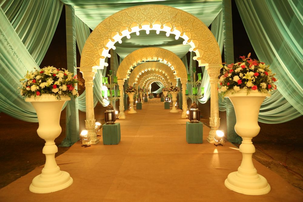 Photo of Archway entrance decor with floral vases and drapes.