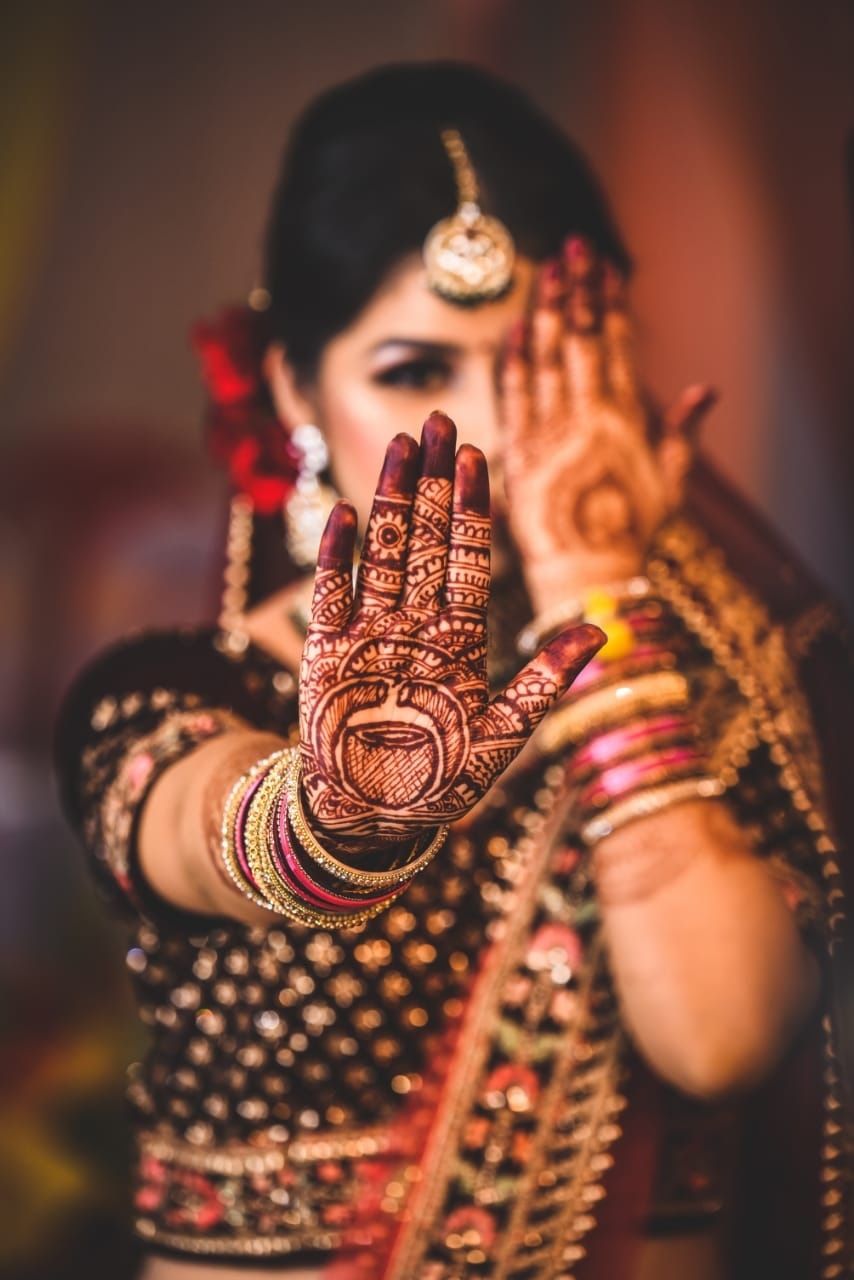 Photo of Bride showing off mehendi hands on wedding day