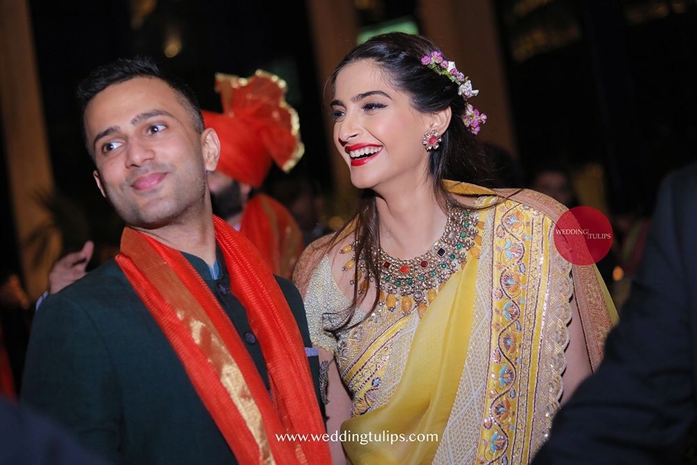 Photo of Sonam kapoor and anand ahuja at moht marwahs wedding in a yellow anamika khanna saree