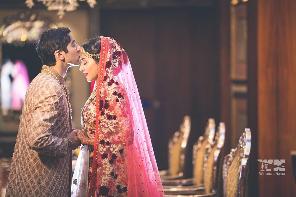 Photo of Groom kissing on bride's forehead.