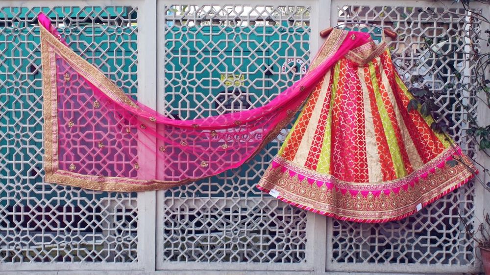 Photo of Pink, Yellow and White Lehenga on a Hanger