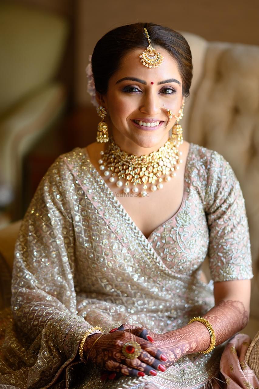 Photo of A closeup of a bride in silver and light pink lehenga on her wedding day