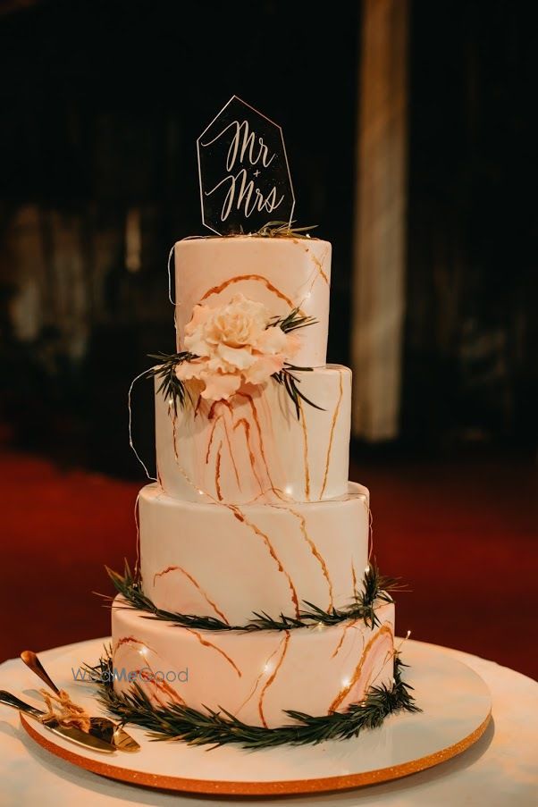 Photo of elegant white and peach wedding cake with topper