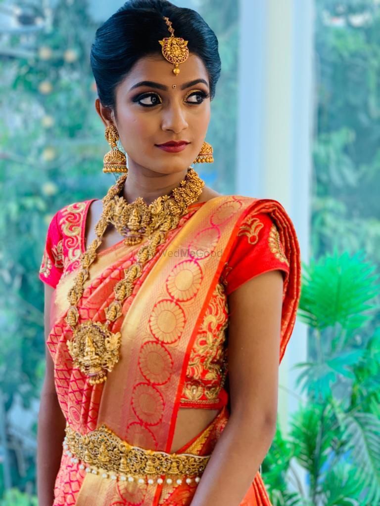 Photo of A bride in a jewel tone kanjeevaram with gold temple jewellery