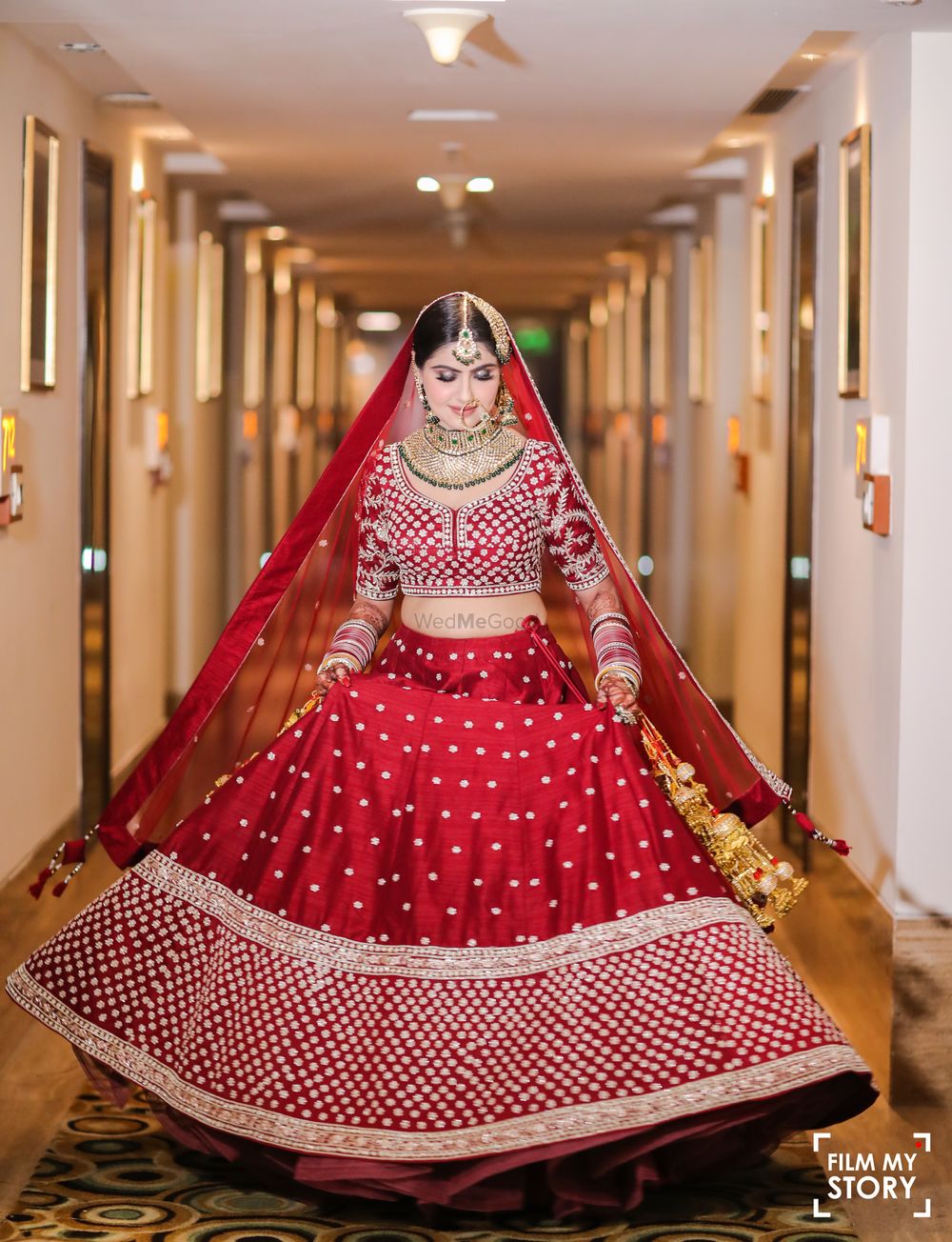 Photo of bride showing off her red velvet bridal lehenga